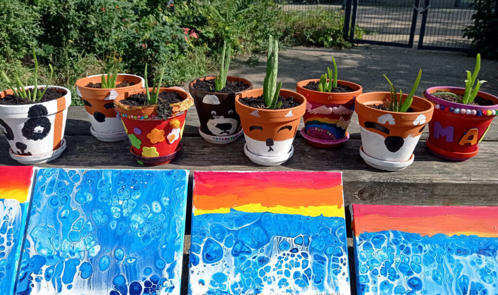 Ergebnisse kreativer Projekte, bunte Blumentöpfe und Bilder
